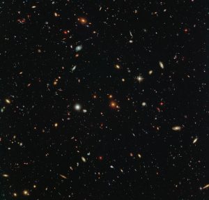 Peering deep into the early Universe, this picturesque parallel field observation from the NASA/ESA Hubble Space Telescope reveals thousands of colourful galaxies swimming in the inky blackness of space. A few foreground stars from our own galaxy, the Milky Way, are also visible. In October 2013 Hubble’s Wide Field Camera 3 (WFC3) and Advanced Camera for Surveys (ACS) began observing this portion of sky as part of the Frontier Fields programme. This spectacular skyscape was captured during the study of the giant galaxy cluster Abell 2744, otherwise known as Pandora’s Box. While one of Hubble’s cameras concentrated on Abell 2744, the other camera viewed this adjacent patch of sky near to the cluster. Containing countless galaxies of various ages, shapes and sizes, this parallel field observation is nearly as deep as the Hubble Ultra-Deep Field. In addition to showcasing the stunning beauty of the deep Universe in incredible detail, this parallel field — when compared to other deep fields — will help astronomers understand how similar the Universe looks in different directions
